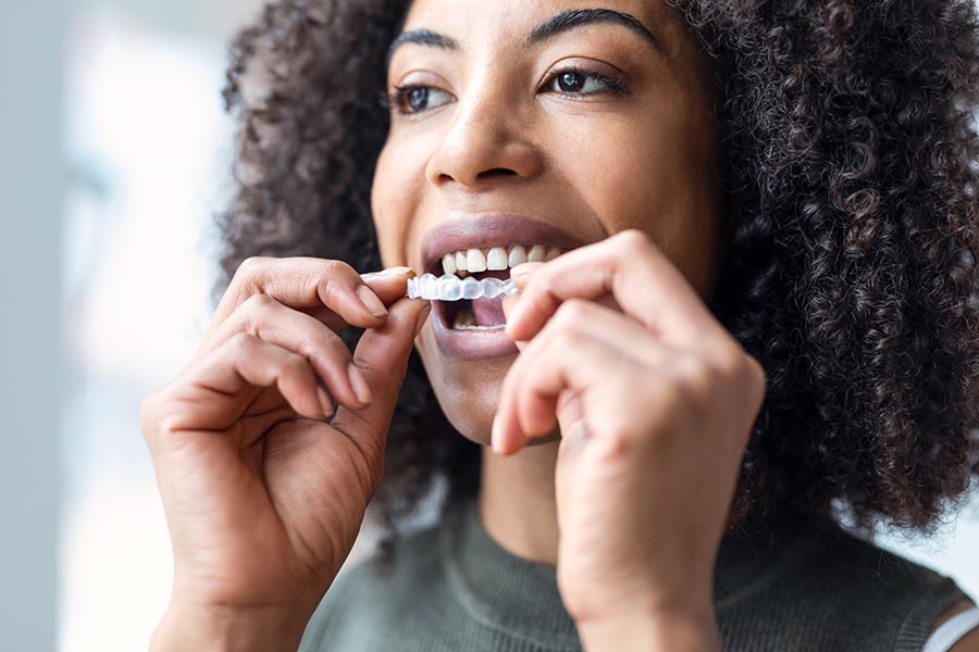 Woman wearing orthodontic silicone trainer. Invisible braces ali