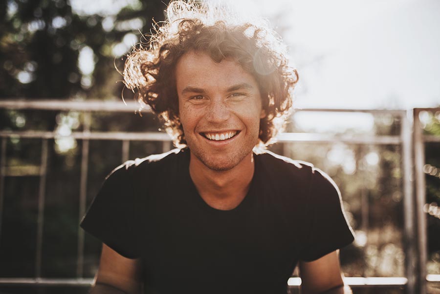 Outdoor closeup portrait of handsome freckled smiling male with