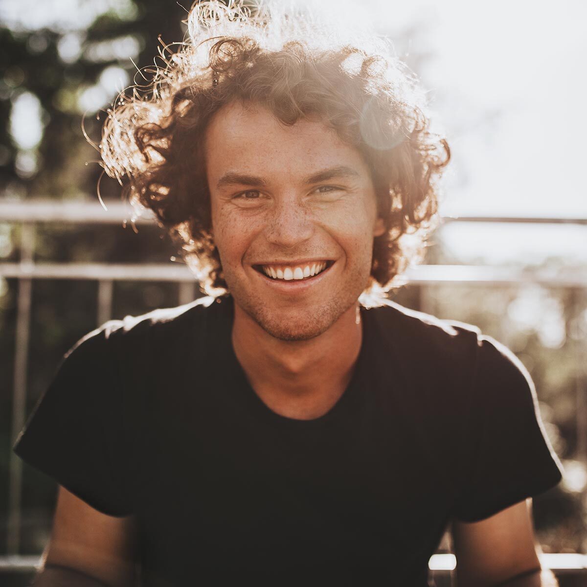 Outdoor closeup portrait of handsome freckled smiling male with